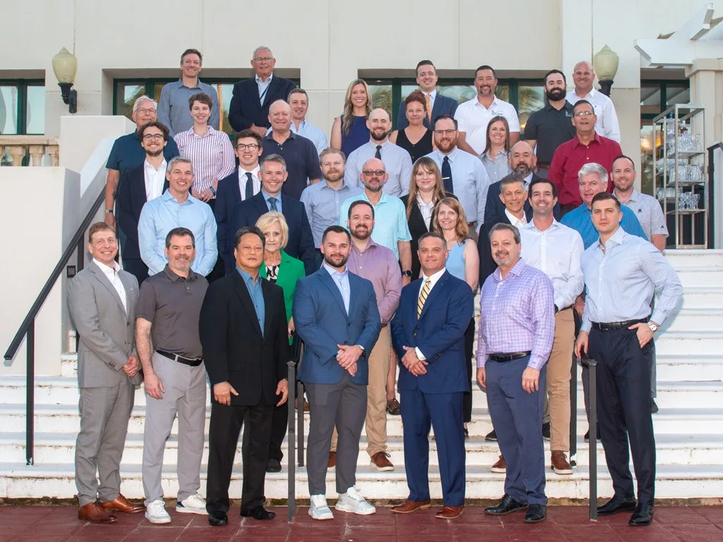 Large group of Forum attendees posing together on a staircase