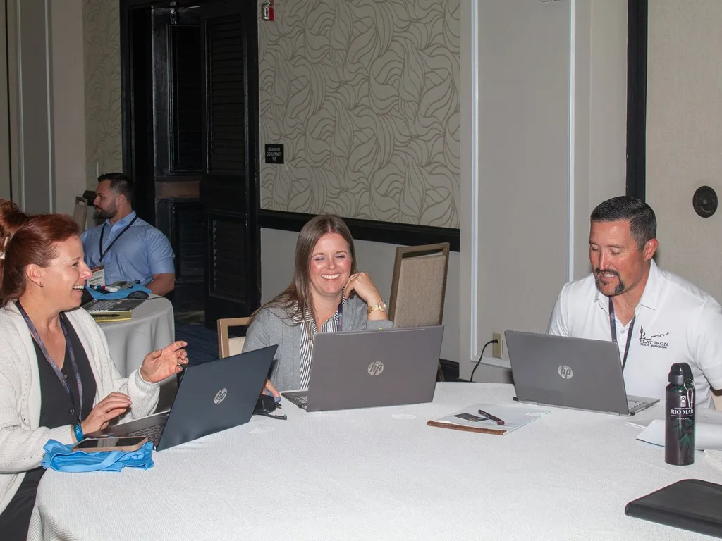 Three advisors talking together around an open laptop