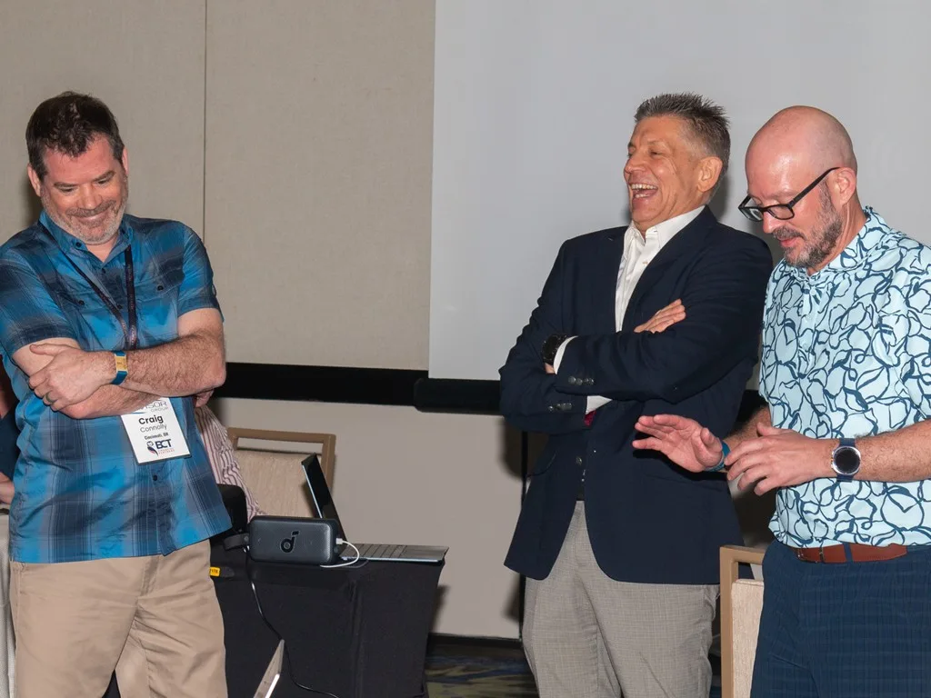 Three advisors laughing together at the Forum