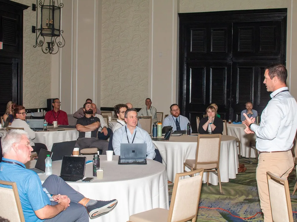 Speaker presenting to a group of seated Forum attendees